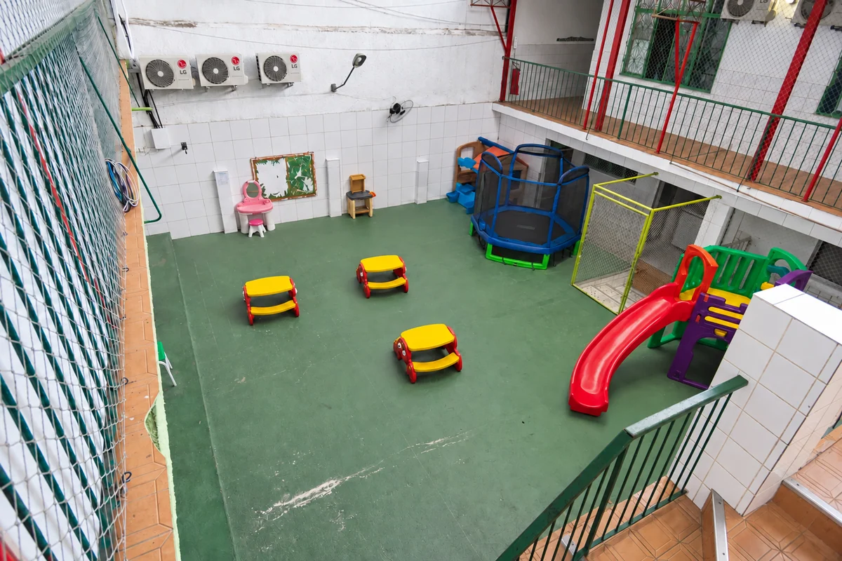 Pátio interno com escorregador, carrinhos e brinquedos